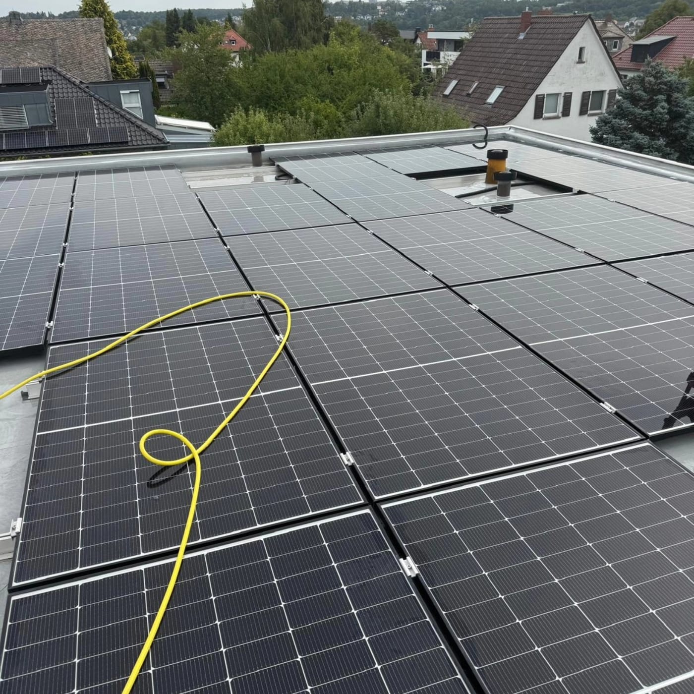 Photovoltaikmodule auf einem Flachdach mit Blick über den Ort