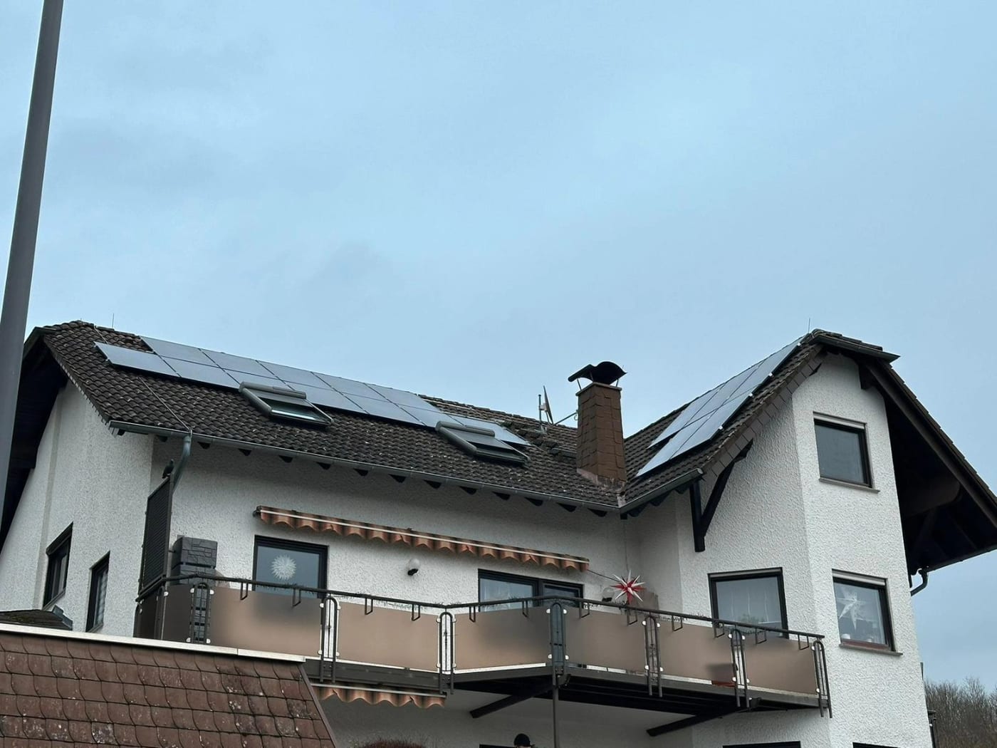 Wohnhaus mit mehreren Dachfenstern und Photovoltaik
