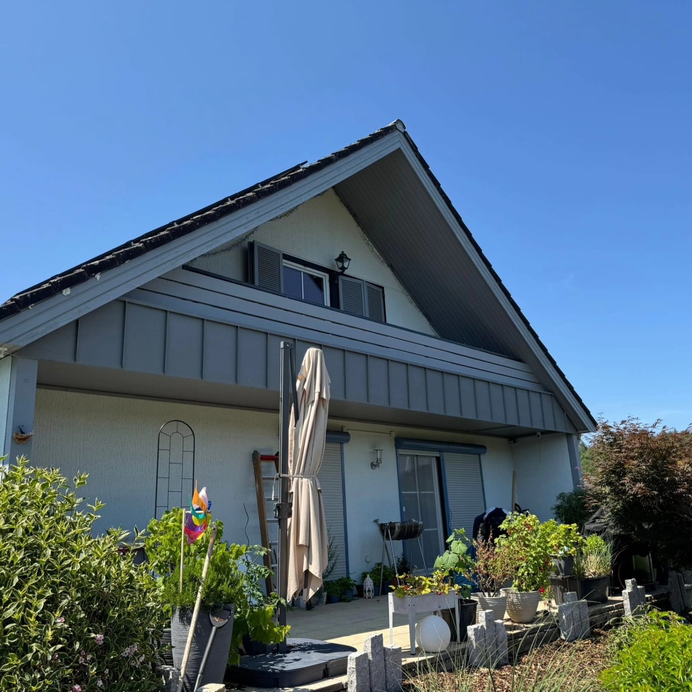 Wohnhaus mit stehfalzverkleidetem Giebel bei Sonnenschein